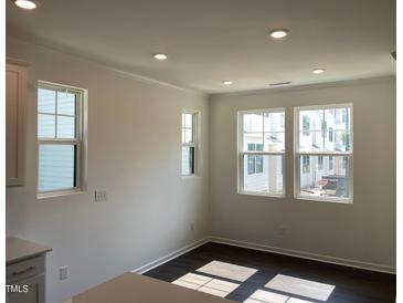 Bright dining area with hardwood floors and multiple windows allowing ample natural light at 3113 White Blossom Ct, Raleigh, NC 27610