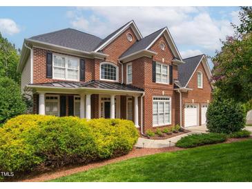 Beautiful brick two-story home with black shutters, white trim, manicured lawn, and mature landscaping at 315 Birdwood Ct, Cary, NC 27519
