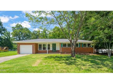 Charming brick home featuring an attached garage and a well-maintained lawn with mature trees at 430 Walnut St, Cary, NC 27511