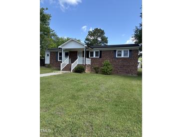 Charming brick home featuring a welcoming entrance and a well-manicured front yard with lush green grass at 501 Morgan Ter, Burlington, NC 27217