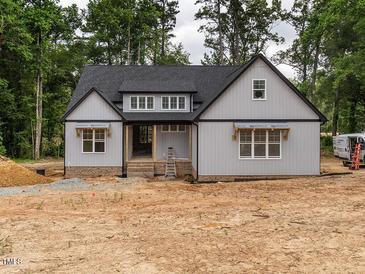 New construction featuring light gray siding, a dark roof, a landscaped yard, and a welcoming front entry at 5027 Preacher Holmes Rd, Graham, NC 27253