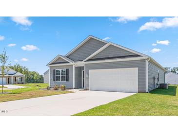 View of the home's exterior featuring a long driveway and large garage at 542 Lochalsh Dr, Gibsonville, NC 27249