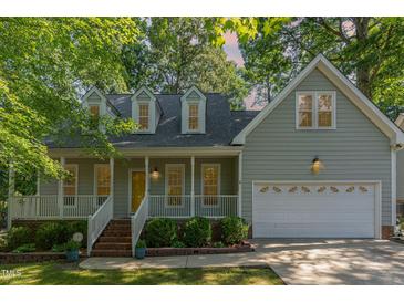 Charming two-story home featuring a welcoming front porch, two car garage, and well-manicured landscaping at 716 Beddingfield Dr, Knightdale, NC 27545