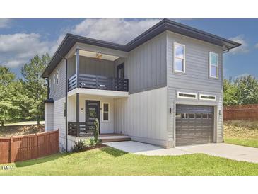 Modern two-story home featuring a two-car garage, a welcoming front porch, and a second-story balcony at 931 Ramseur St, Durham, NC 27701