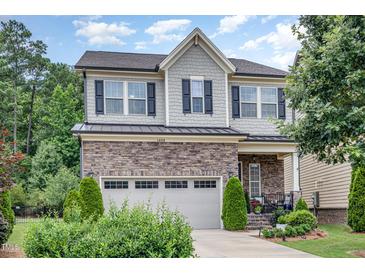 Charming two-story home featuring stone accents, a two-car garage, and landscaped front yard at 1020 Regency Cottage Pl, Cary, NC 27518
