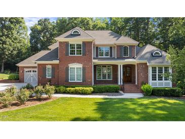 Charming two-story brick home featuring a well-manicured lawn, classic shutters, and inviting front entrance at 1028 Harpers Ridge Ct, Wake Forest, NC 27587
