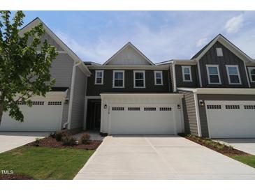 Charming townhome with attached two-car garage and a concrete driveway at 1218 Tredenham Way, Durham, NC 27703