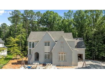 A charming new construction home with grey painted brick, gabled roof, and ample windows at 1529 Lake Adventure Ct, Raleigh, NC 27613