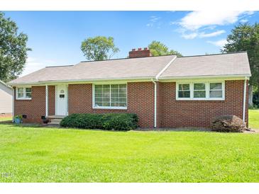 Charming single story brick home with a well-manicured lawn and mature trees at 1702 Pinecrest St, Burlington, NC 27215