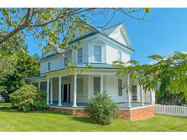 Charming two-story home boasts a wrap-around porch with stately columns and a metal roof at 29 Oak St, Roxboro, NC 27573