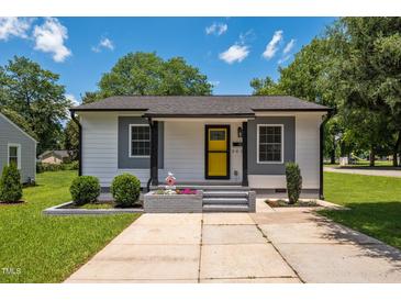 Charming home featuring a bright yellow door, gray accents, and professional landscaping for great curb appeal at 301 Williamson St, Burlington, NC 27215