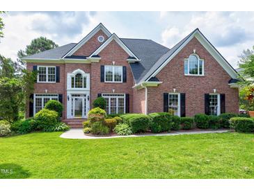 Beautiful two-story brick home with manicured lawn and lush landscaping at 500 Walcott Way, Cary, NC 27519