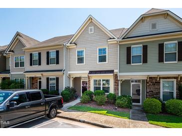 Townhomes feature manicured landscaping, covered entries, and visible house numbers for easy identification at 7809 Lillyhurst Dr, Raleigh, NC 27612