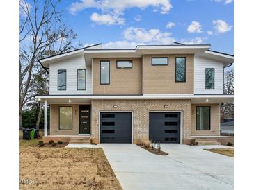 Modern duplex with brick accents, black garage doors, and a contemporary design under a partly cloudy sky at 810 Culpepper Ln, Raleigh, NC 27610