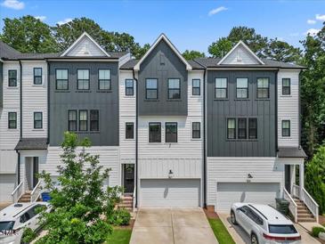 Charming townhome showcases a two-tone color scheme, complemented by individual garages and well-maintained landscaping at 907 Lake Beacon Way, Raleigh, NC 27606