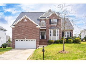 Charming two-story brick home featuring a well-manicured lawn and a two-car garage at 9220 Cornwell Dr, Wake Forest, NC 27587
