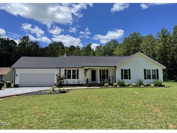 Charming single-story home featuring a two-car garage and well-manicured lawn at 956 W Greensboro Chapel Hill Rd, Snow Camp, NC 27349