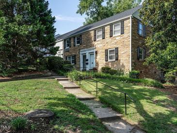 Charming two-story stone home featuring black shutters and a well-manicured front yard at 979 St Marys St # G6, Raleigh, NC 27605