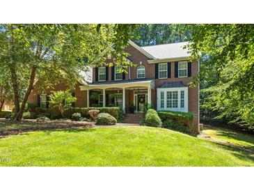 Beautiful brick home featuring a lush front yard and welcoming front porch at 1008 Old Meetinghouse Way, Raleigh, NC 27615
