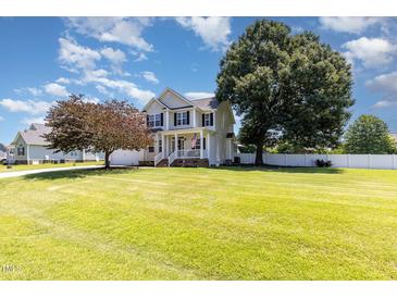 Charming two-story home featuring a lush green lawn and a welcoming front porch at 114 Boone Trl, Garner, NC 27529