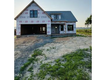 New construction home with an attached two-car garage, front porch, and black window frames at 1327 Parkertown Rd, Four Oaks, NC 27524