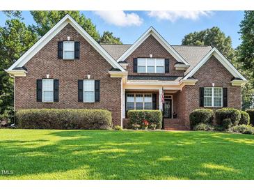 Charming two-story brick home with a manicured lawn and neatly trimmed hedges at 164 Avocet Ln, Clayton, NC 27520