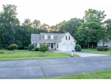 Charming two-story home with manicured lawn, two-car garage, and surrounded by lush trees at 237 Water Front Ln, Timberlake, NC 27583