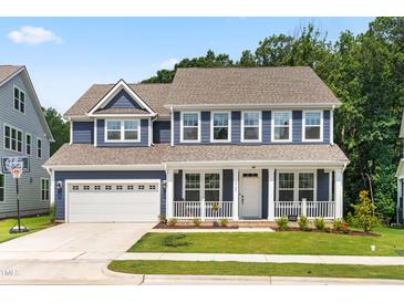 Charming two-story home featuring blue siding, a welcoming front porch, and a convenient attached two-car garage at 2720 Spotted Coral Ct, Apex, NC 27502