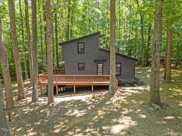 Unique exterior of a modern home featuring a large deck and surrounded by lush trees at 3218 Seven Springs Rd, Hillsborough, NC 27278