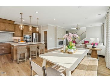 Charming eat-in kitchen features an island with seating, wood cabinets, and stainless steel appliances at 610 Callan View Ave, Wake Forest, NC 27587