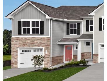 Charming two-story home with a gray exterior, stone accents, and a two-car garage for convenient parking at 6657 Gibraltar Rock Dr, Raleigh, NC 27610