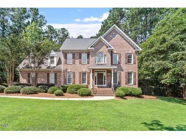 Traditional brick home with manicured lawn and mature trees at 7801 Kingsbrook Ct, Wake Forest, NC 27587