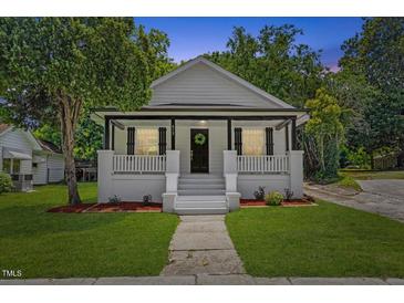 Charming home featuring a welcoming front porch and landscaped front yard at 813 N Main St, Burlington, NC 27217