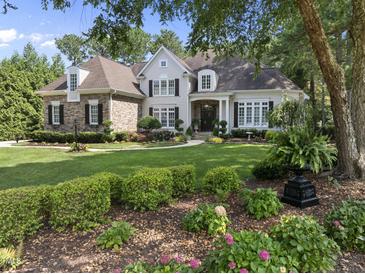 Charming two-story home with stone accents, manicured lawn, and lush landscaping at 8416 Davishire Dr, Raleigh, NC 27615