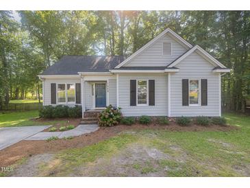 Charming single-story home featuring a blue front door and manicured landscaping at 1008 Alderleaf Dr, Fuquay Varina, NC 27526