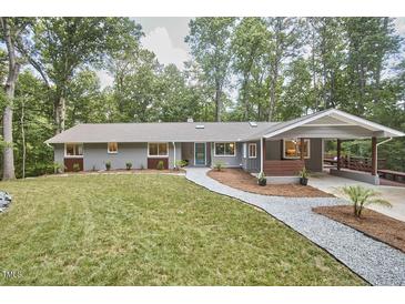 Charming single-story home with a manicured lawn, a welcoming walkway, and an attached carport at 108 Cedar St, Chapel Hill, NC 27514