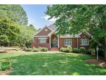 Charming brick home featuring a well-manicured lawn, beautiful landscaping, and inviting front entrance at 109 Fox Trap Ct, Garner, NC 27529