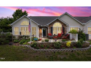 Charming home exterior with stone accents, landscaped yard, and cozy patio seating at 1167 Blue Bird Ln, Wake Forest, NC 27587