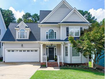 Charming two-story home with a manicured lawn, attached garage, and inviting front porch at 1276 Dalgarven Dr, Apex, NC 27502