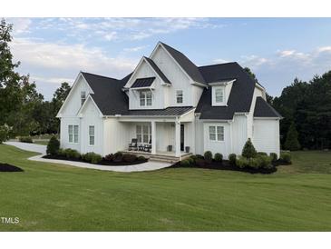 Beautiful new construction home with white siding, black roof, and manicured landscaping at 20 Delia Ln, Pittsboro, NC 27312