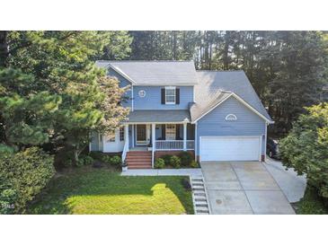 Charming two-story home with a welcoming front porch and a well-manicured lawn surrounded by mature trees at 302 Caraway Ln, Cary, NC 27519