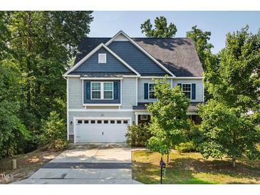 Charming two-story home with a blue and gray exterior, well-maintained lawn, and attached two-car garage at 3401 Grosbeak Way, Raleigh, NC 27616