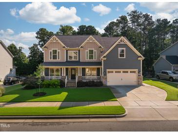 Charming two-story home featuring a manicured lawn, two-car garage and inviting front porch perfect for relaxing at 3624 Regent Pines Dr, New Hill, NC 27562