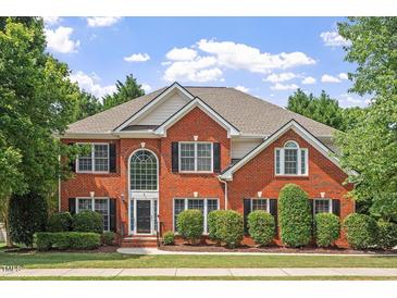 Beautiful two-story brick home with black shutters, manicured lawn, and lush landscaping at 3812 Covina Dr, Raleigh, NC 27613