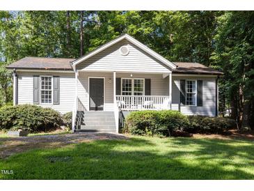 Charming home featuring a quaint front porch, neutral siding, and lush green lawn at 472 Shawnee Dr, Louisburg, NC 27549