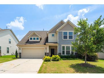 Two-story home with a two-car garage, landscaped yard, and a combination of siding and stone accents at 517 Eagles Way, Mebane, NC 27302