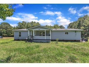 Exterior view of a one-story home with a front porch and grassy yard at 64 Doughty Ln # E, Middlesex, NC 27557