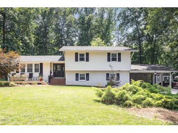 Charming two-story home with a well-manicured lawn and mature trees, showcasing classic curb appeal at 6609 Electra Dr, Raleigh, NC 27607