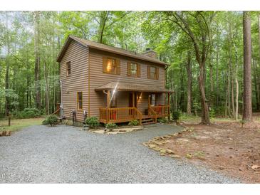 Charming home nestled amongst mature trees with a cozy front porch and gravel driveway at 1012 King Cir, Chapel Hill, NC 27516