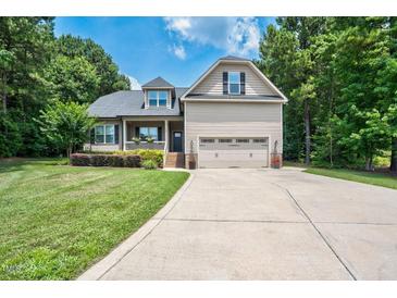 Charming two-story home with a well-manicured lawn and attached two-car garage at 109 Box Elder Way, Zebulon, NC 27597